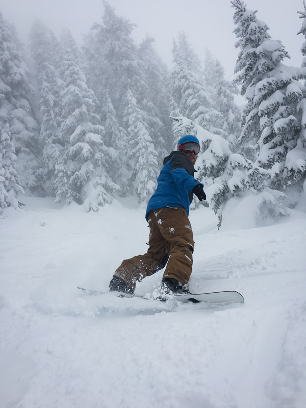Brian snowboarding through deep powder