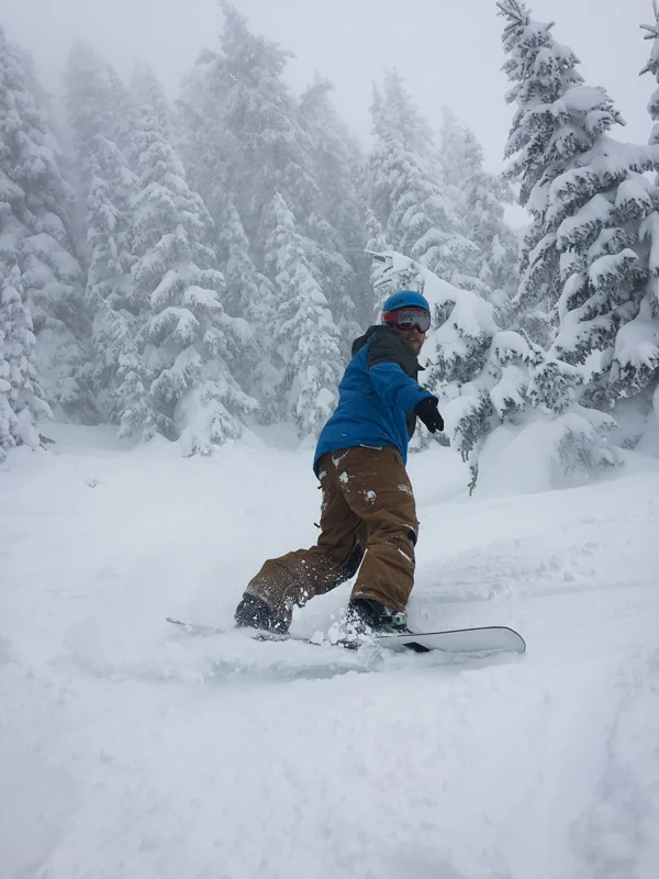 Brian snowboarding through deep powder
